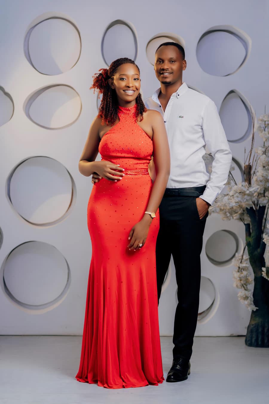 Celine in a red gown standing beside Khalim